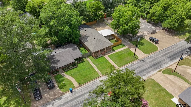 an aerial view of a house with a yard and trees