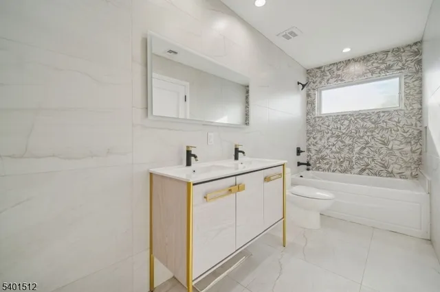 a bathroom with a bathtub sink and mirror