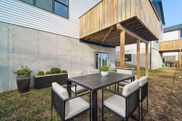 a view of a backyard with table and chairs and potted plants