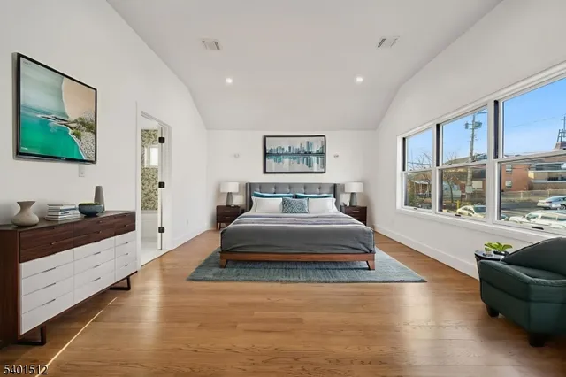 a spacious bedroom with a large bed and a flat screen tv