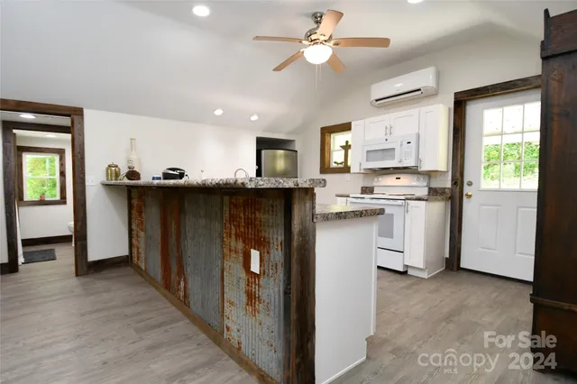 a kitchen with stainless steel appliances granite countertop a stove a sink dishwasher a refrigerator and a dining table with wooden floor