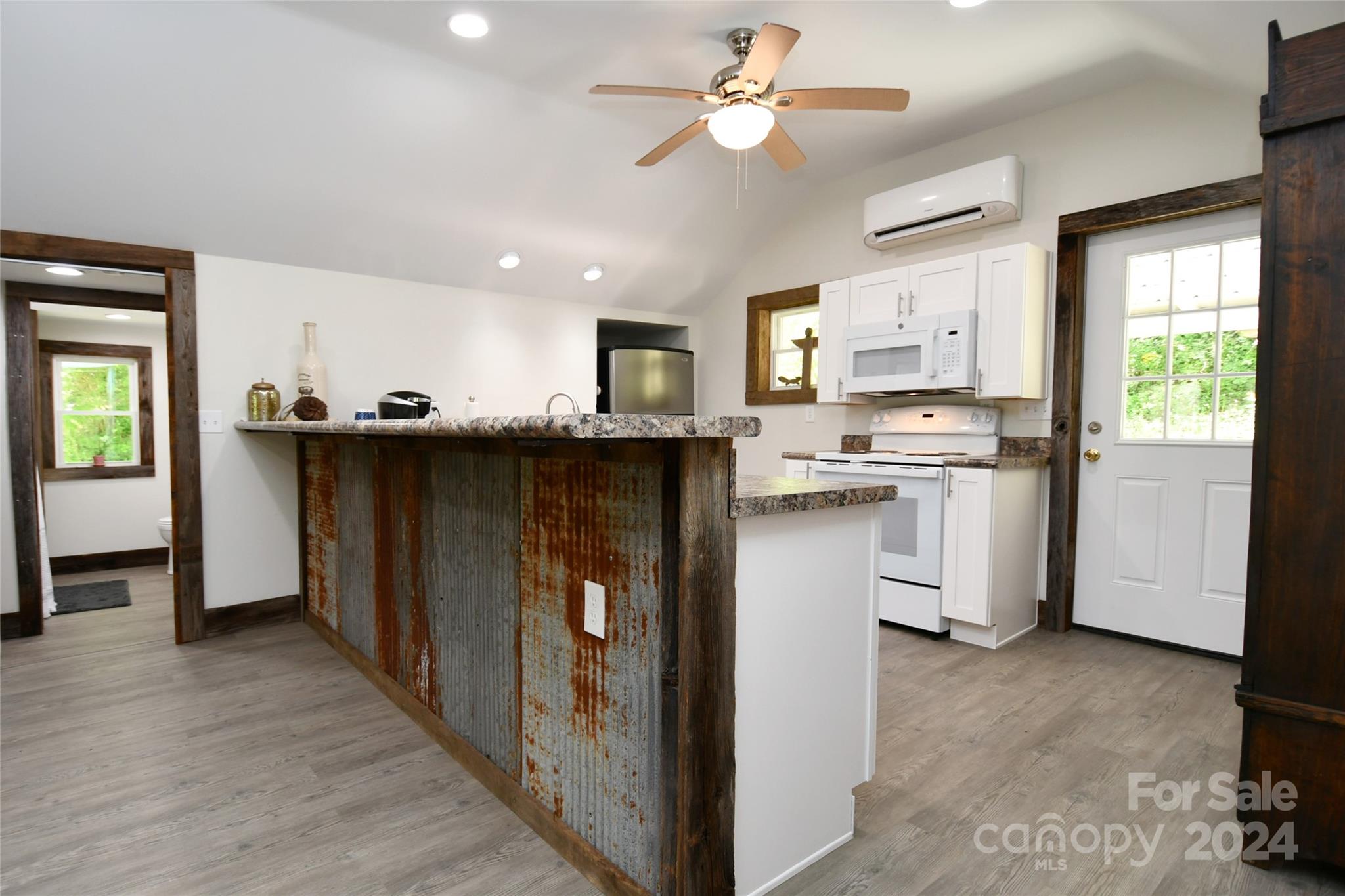 2180 Pigeon Roost Road Green Mountain, NC 28740 - Photo 14 of 47 a kitchen with stainless steel appliances granite countertop a stove a sink dishwasher a refrigerator and a dining table with wooden floor