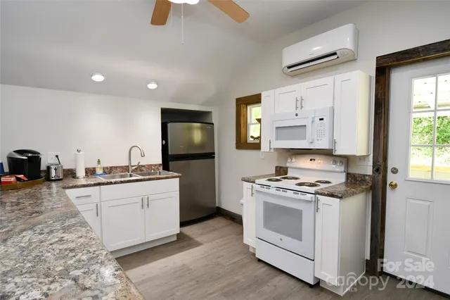 a kitchen with stainless steel appliances granite countertop a stove a sink and a refrigerator