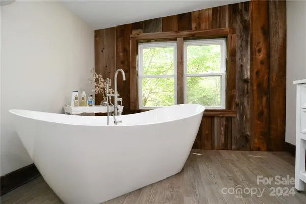 a white bath tub sitting in a bathroom next to a window