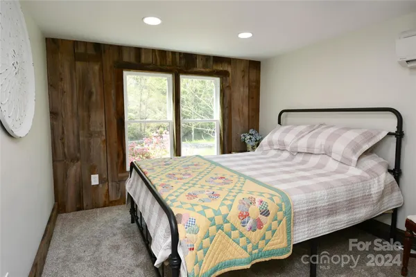 a bedroom with a bed and a large window