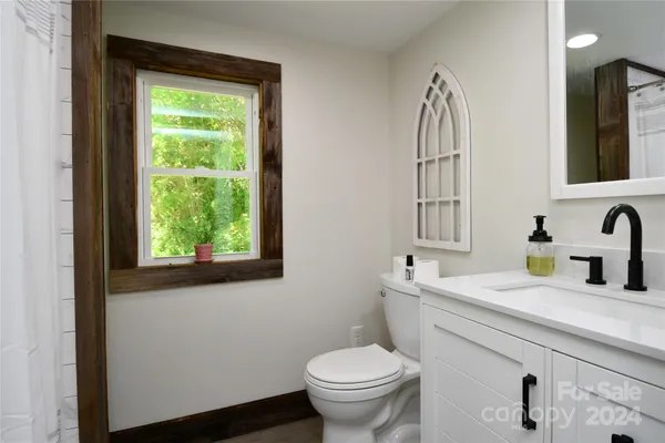 a bathroom with a granite countertop toilet sink and mirror