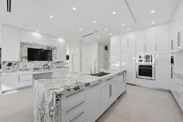 a living room with couches and kitchen view with wooden floor