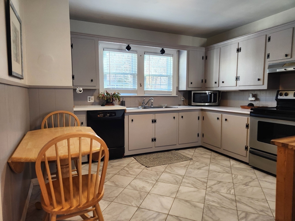 350 Thompson Road Webster, MA 01570 - Photo 17 of 41 a kitchen with granite countertop a sink a stove a microwave and cabinets