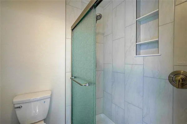 a bathroom with a toilet and a shower