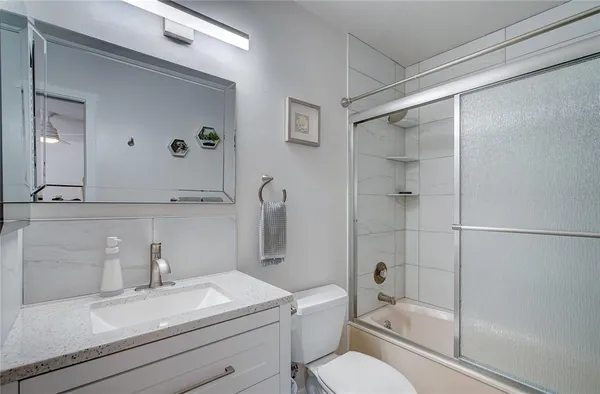 a bathroom with a sink toilet a mirror and shower