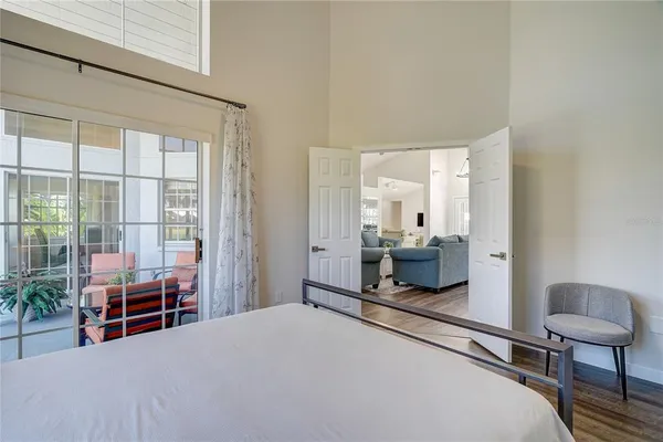 a bedroom with a bed and large windows