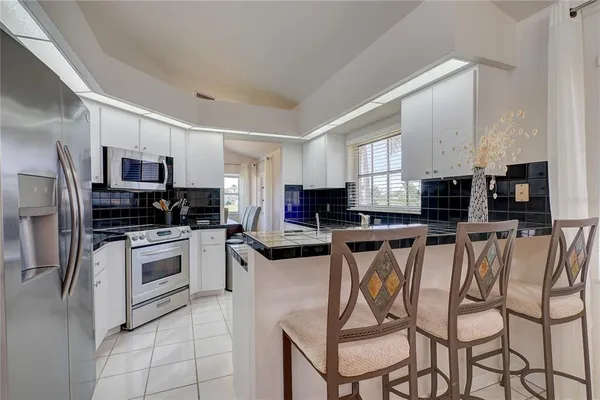 a kitchen with stainless steel appliances granite countertop a stove a sink a microwave and a refrigerator