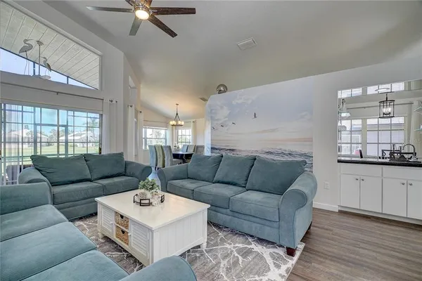 a living room with furniture and kitchen view