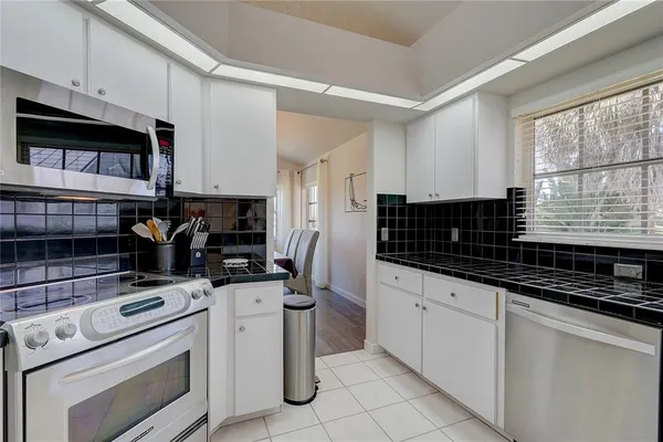 a kitchen with stainless steel appliances a stove sink microwave and cabinets