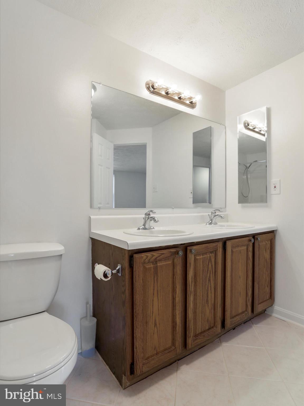 811 Stratford Way, Unit D Frederick, MD 21701 - Photo 13 of 25 a bathroom with a double vanity sink and a toilet
