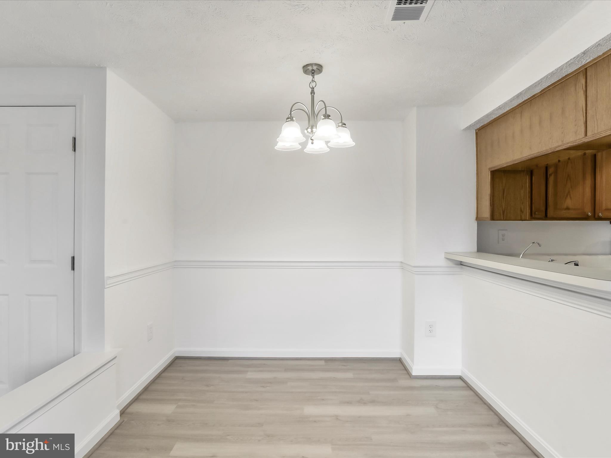 811 Stratford Way, Unit D Frederick, MD 21701 - Photo 7 of 25 a view of a utility room with wooden floor and staircase