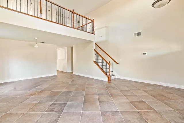 a kitchen with granite countertop a sink stainless steel appliances wooden floor and a window