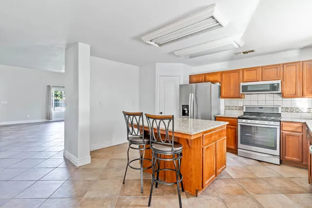 a kitchen with stainless steel appliances granite countertop a refrigerator and a sink