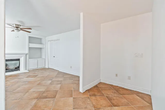 a view of an empty room with a fireplace and a window