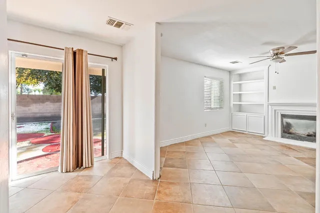 a view of an empty room with a fireplace and a window