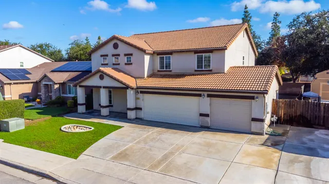 a front view of a house with a garden and yard