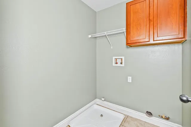 an empty room with wooden floor closet and fan