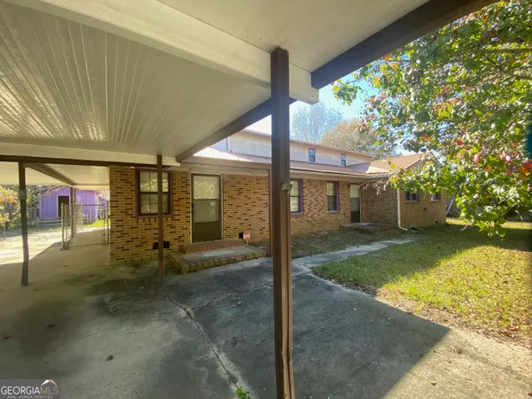 a view of a porch with furniture and a yard