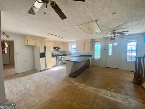a view of a kitchen with refrigerator and windows