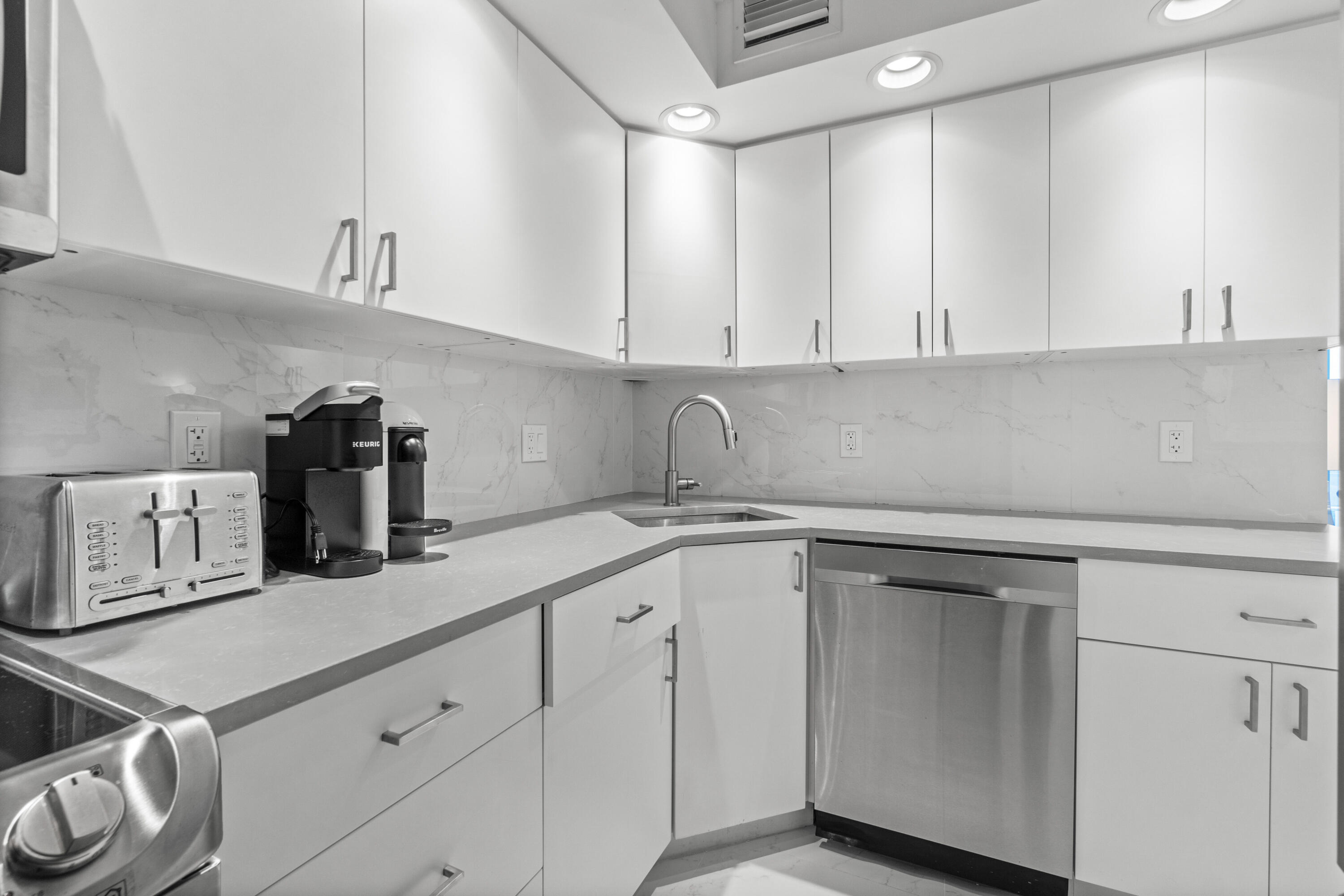 2780 South Ocean Boulevard, Unit 306 Palm Beach, FL 33480 - Photo 12 of 37 a kitchen with white cabinets and sink