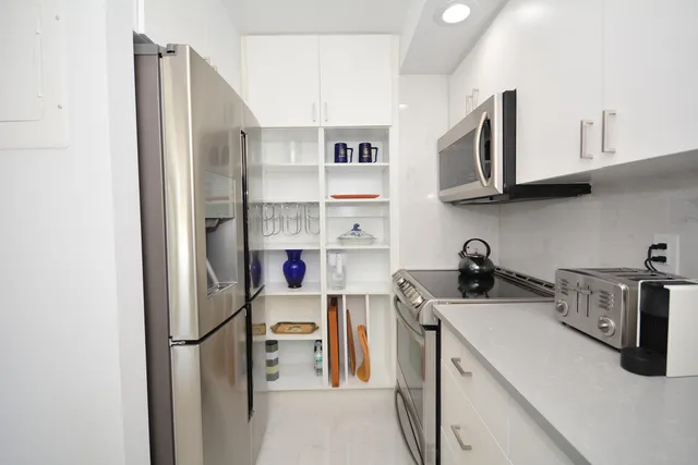 a kitchen with stainless steel appliances granite countertop a refrigerator sink and stove
