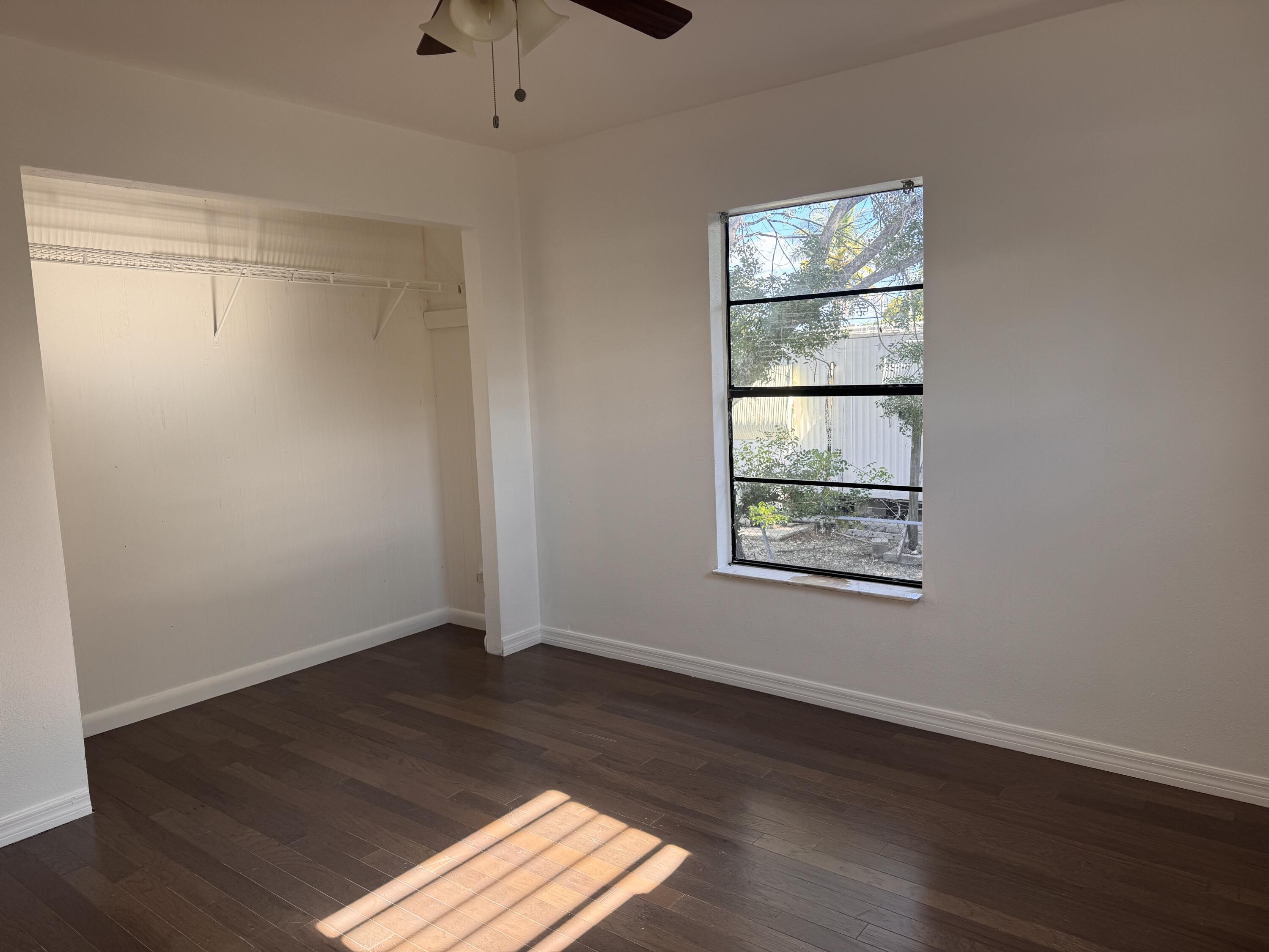 969 Plantation Road Key Largo, FL 33037 - Photo 12 of 26 a view of empty room with wooden floor and fan
