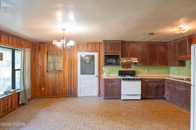 a kitchen with kitchen island granite countertop stainless steel appliances a sink refrigerator stove microwave and cabinets