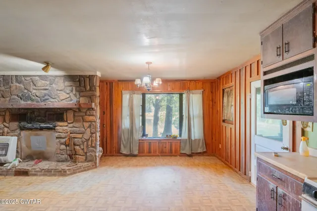 a view of an empty room with a fireplace and a window