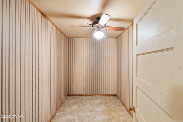 a view of a hallway with a chandelier fan