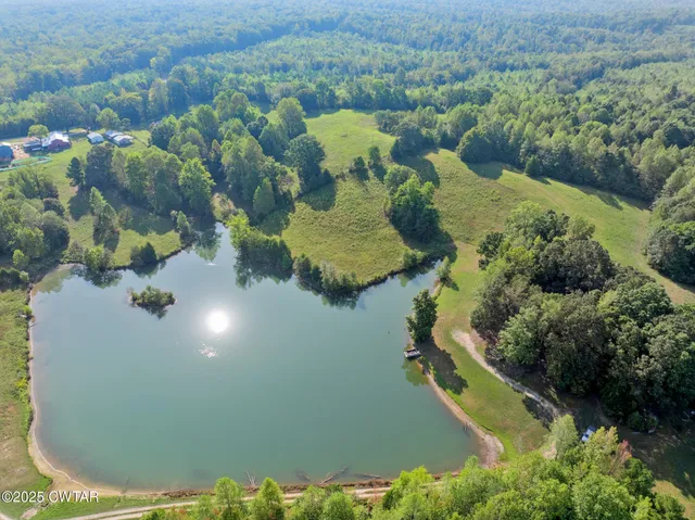 an aerial view of a house with a yard and lake view