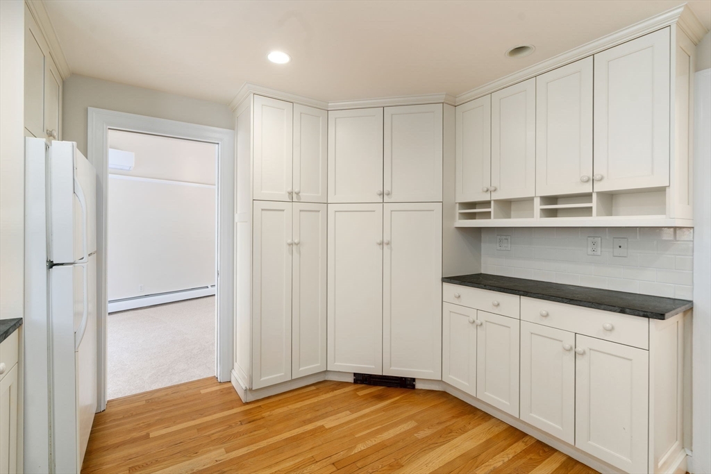 101 Adams Road Concord, MA 01742 - Photo 18 of 26 a view of a kitchen with wooden floor and cabinets