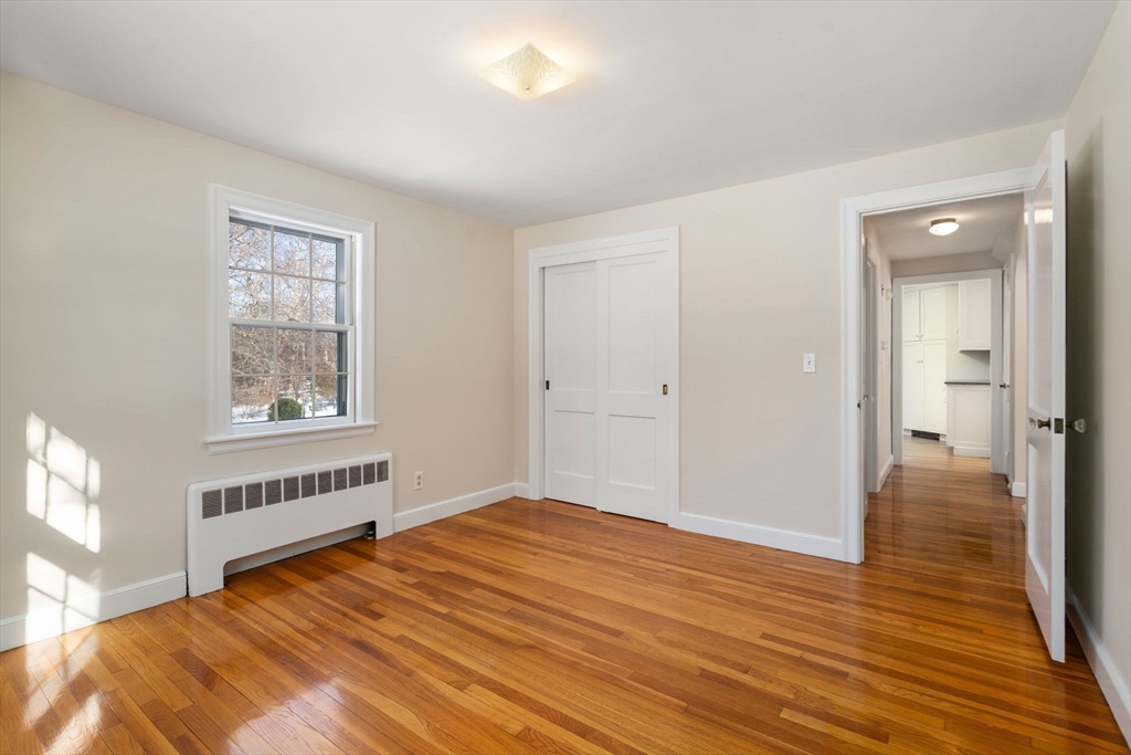 101 Adams Road Concord, MA 01742 - Photo 20 of 26 a bedroom with a bed and wooden floor