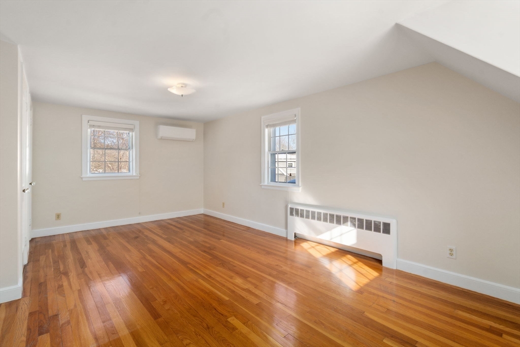 101 Adams Road Concord, MA 01742 - Photo 21 of 26 an empty room with wooden floor and windows