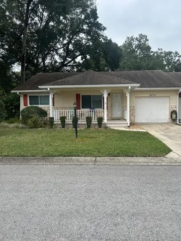 front view of a house with a yard and potted plants
