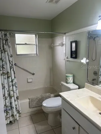 a bathroom with a granite countertop sink mirror vanity and toilet