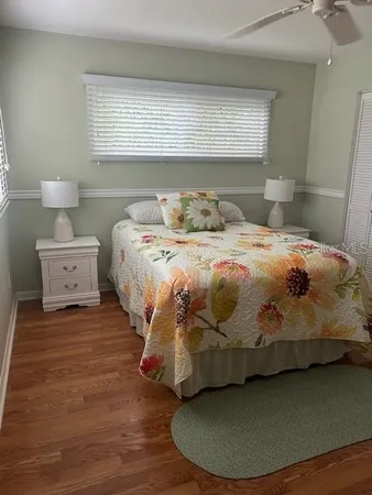 a bedroom with a bed and a wooden floor