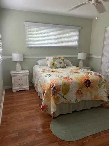 a bedroom with a bed and a wooden floor