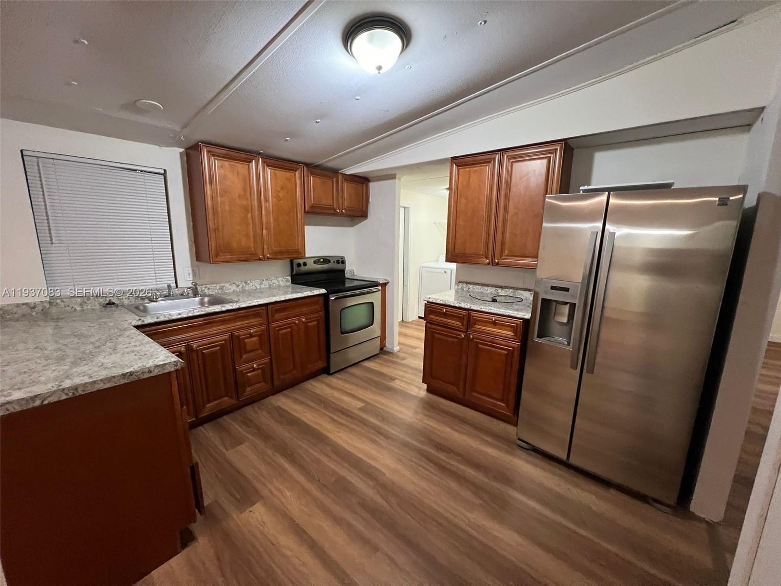 10492 South 228th Lane, Unit A Boca Raton, FL 33428 - Photo 18 of 37 a kitchen with granite countertop a refrigerator a sink a stove and cabinets