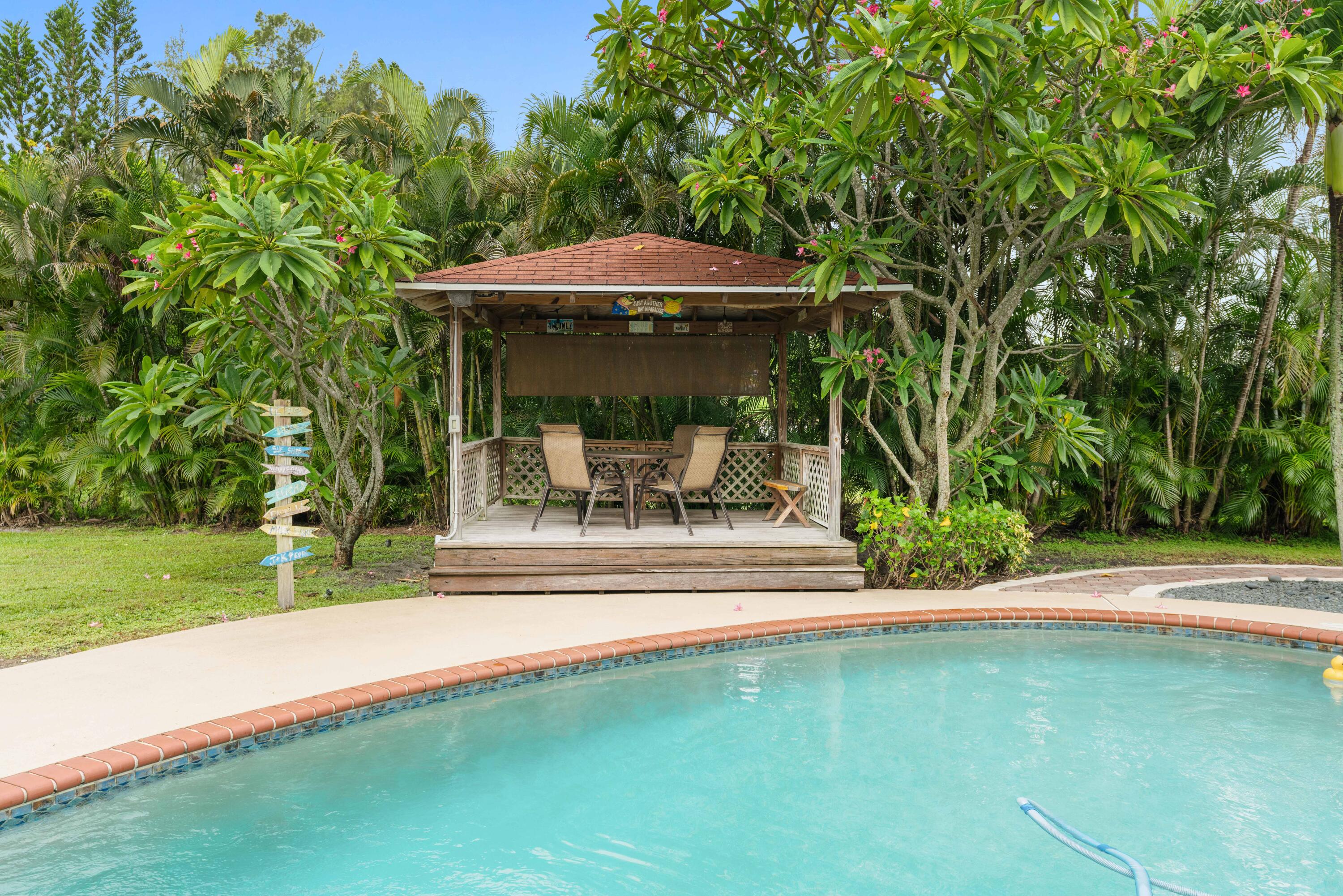 212 West Whitney Drive Jupiter, FL 33458 - Photo 8 of 23 a view of a porch with a table and chairs under an umbrella