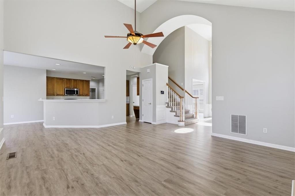 1660 Rosemist Trail Grayson, GA 30017 - Photo 13 of 52 a view of a livingroom with wooden floor and a ceiling fan