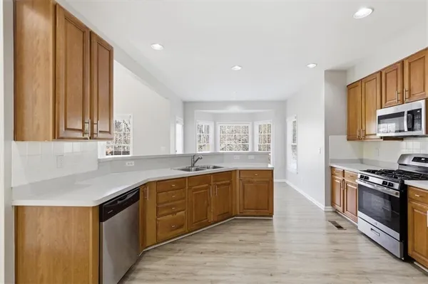 a large kitchen with granite countertop a stove and a sink