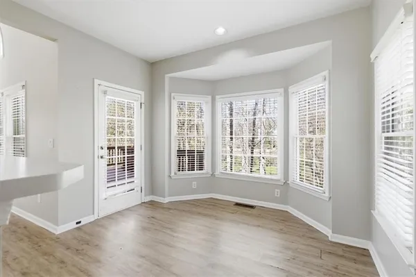 a view of a kitchen with kitchen island a sink wooden floor and stainless steel appliances