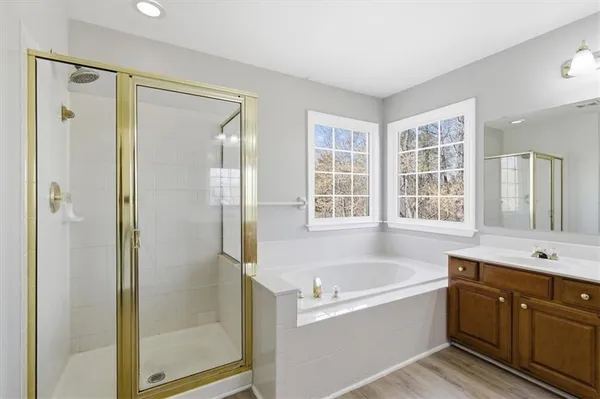 a spacious bathroom with a tub shower and sink