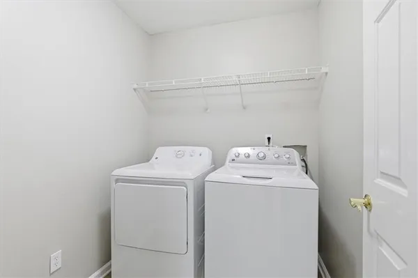 a kitchen with granite countertop a stove a sink dishwasher and white cabinets with wooden floor next to windows