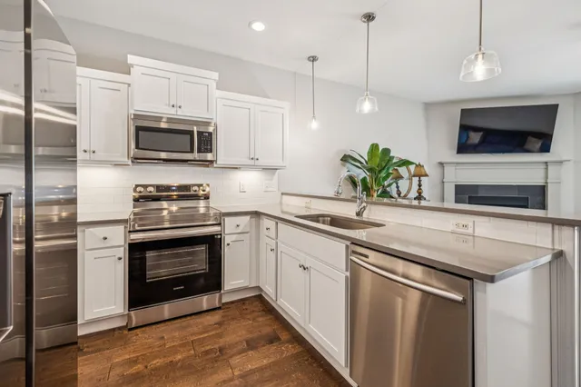 a kitchen with stainless steel appliances a stove microwave and sink